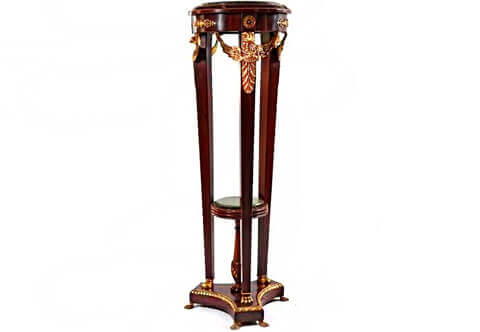 A dignified French 19th Century Empire style ormolu-mounted and veneer inlaid Pedestal Stand after the model by François-Honoré-Georges Jacob-Desmalter; raised on a triform concaved sides plinth with pair of ormolu lion paw feet to each of its corners and adorned with Egg-and-Dart ormolu trim on the edge, above are three tapering slender supports resting on another style of ormolu lion paw feet and surmounted with finely and masterfully chiseled winged eagle on an ormolu acanthus spinosus leaf extension; the upper circular tier is ornamented with circular ormolu rosettes and pierced floral ormolu mounts; the surmounting protruding top part has and inset marble top surrounded with pair of twisted ormolu bands and decorations of ormolu acanthus spinosus leaves; the three supports surrounding a central marble topped Tazza as a stretcher resting on a baluster shaped foot and ornamented with ormolu twisted bands and ormolu acanthus leaves.