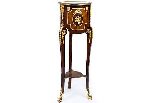 Régence style Pedestal, French Régence style Stand, Luxurious Pedestals, Jean-Henri Riesner Pedestal, Francois Linke Pedestal, Maison Millet Pedestal, Corners Decoration, French style Stand, Andres Charles Boulle Pedestal, Theodore Millet Style Pedestal, Robert Adam style Vase Stand, Empire Style Pedestal, Vitrine Stands, Louis XV style Pedestals, Bombe Shape Stand, Louis XVI Pedestals, Ormolu-mounted Stand, English style Pedestal, Empire style Pedestal, George III style Pedestals, Heritage Pedestals, Display Stands, French Régence style mahogany ormolu-mounted veneer inlaid torcheres pedestal, The inset beveled and moulded marble top within a brass bad above a double veneer inlaid three sectional circular cylinder body, each section is centered with ormolu musical instruments medallion mount within ormolu ribbon tied oval beaded frame bordered with another shaped beaded encadrement flanked to each upper concave side with an ormolu flower rosette, Each block between sections is ormolu adorned with a fine ribbon tied suspending foliage confronting a richly chiseled large ormolu laurel chutes applied to each leg, The body is resting a tall cabriole slender S scrolled supports headed with a flower rosette issuing a scrolling acanthus leaf terminating with laurel leaves on the front part of the turning leg and a musical trumpet with rosette issuing acanthus leaf to each side. The supports are connected with a veneer inlaid shaped bottom tier ornamented with a hammered brass band