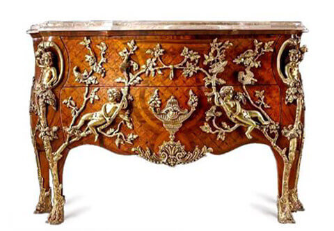 An extraordinary French Louis XV Régence style gilt-ormolu-mounted parquetry commode à pipée des oiseaux after the celebrated model by Charles Cressent by Maison Millet circa 1720, Paris, with serpentine marble top above a pair of drawers inlaid with trellis parquetry, centered by ormolu urn flanked by reclining putti and courting doves on oak branches and foliate ormolu works above a serpentine scalloped  apron centered by a fine burnished leafy shell cartouche, the angles with crossed oak trunks with a putto to each angle holding a bird, raised on four cabriole tapering legs with leafy ormolu oak-trunk front cast sabots