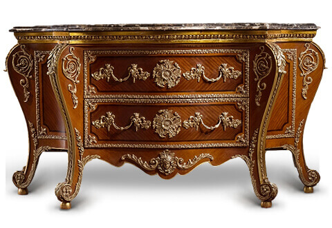 A splendid George iii style ormolu-mounted and quarter veneer inlaid bombe commode after the model by cabinet-maker Pierre Langlois which probably made for Princess Amelia of Great Britain (d.1786), With a lavish use of ormolu-mounting; The ormolu-bound serpentine-fronted top is marble topped and molded with large ormolu Egg-and-Dart cornice above two long drawers mounted with large rosettes and cornucopia handles with diaper and mask backplates, all within cabochon and acanthus borders, the apron with central Zephyr-mask flanked by scrolling acanthus, the voluted legs headed by acanthus, the concave sides similarly paneled and mounted with a rosette within foliate borders, ending in scrolled feet on brass ball supports, the back and underside blackened, with pegged construction, the side of the top drawer stenciled