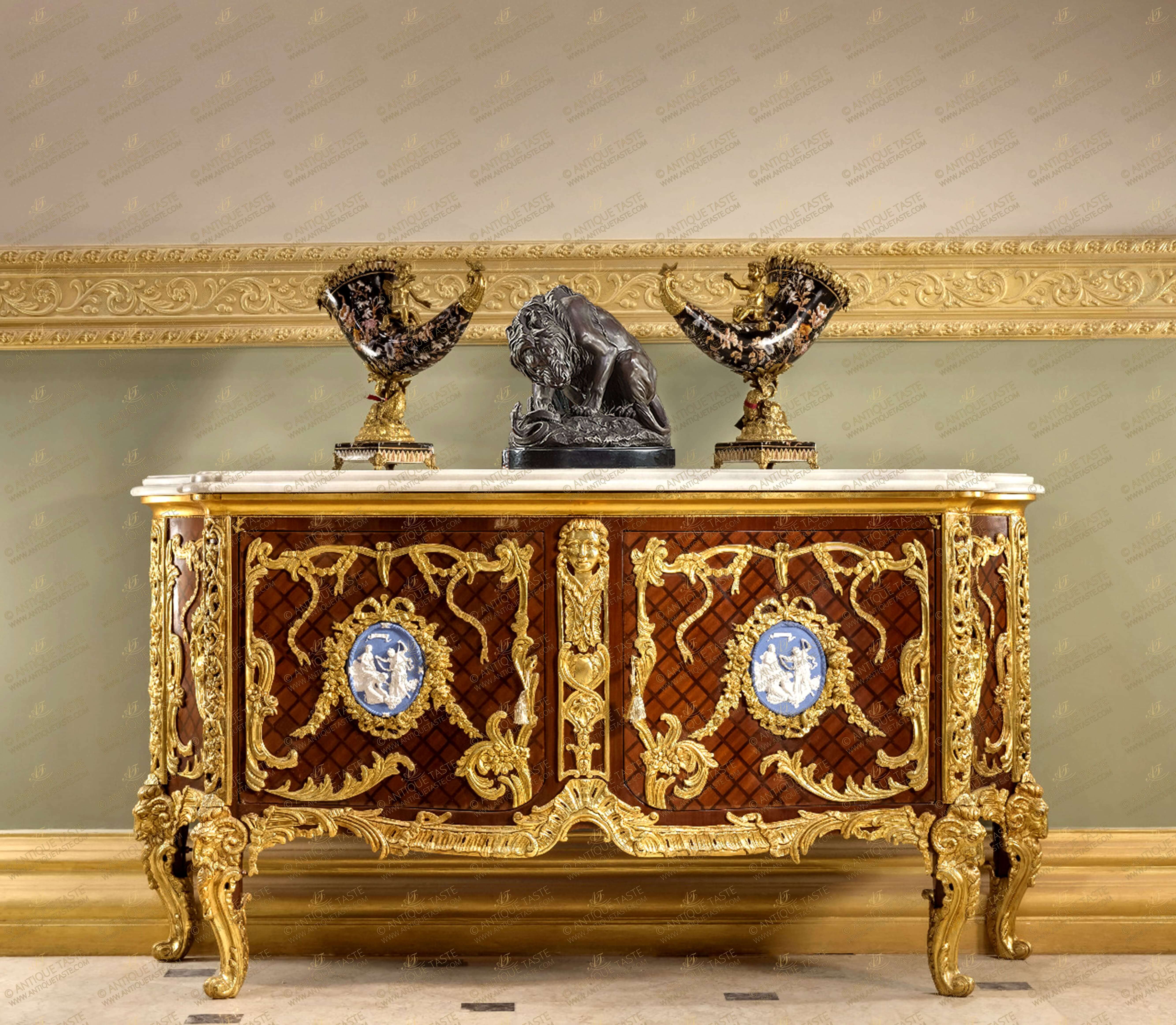 A French late 19th century Louis XV style gilt-ormolu-mounted and veneer parquetry inlaid commode a vantaux after the model Commode Médaillier designed by the Slodtz brothers and executed by Antoine-Robert Gaudreaux, made for le cabinet du Roi at Versailles with a serpentine veined moulded marble top above a pair of doors with one tier inside, each door centered by an ormolu oval one with a cherub and goat, the other oval with Ariadne on a leopard, all within marvelously chiseled  ribbon-tied acanthus leaves and blossoming flower swaging  garlands, all on a diamond parquetry ground veneer inlay centered by an ormolu female mask on scrolling ormolu works and shell on a very fine ormolu scalloped shell form apron with acanthus leaves scrolls, the sides each with a further similar oval medallion within the same ormolu tied scrolling frame, and raised on astonishingly chiseled and burnished ormolu cabriole legs with scrolled ram-headed capitals, The original precious commode-médaillier was designed and created in 1739 for the king's use in Louis XV's Cabinet à Pans at Versailles. It is now in the Cabinet des Médailles at the Bibliothèque Nationale, This commode is based on the famous kingwood medal cabinet supplied by the Royal cabinet-maker Antoine-Robert Gaudreaus (1682-1746) on 10 January 1739 for the Cabinet Interieur. It was referred to at the time as 'Par les Srs Gaudreaux ébéniste et Slodtz frères, sculpteurs, pour servir dans le cabinet aux tableaux avant la petite galerie à Versailles '. The bronze mounts were modelled by the Slodtz brothers. The commode was a popular model amongst Parisian makers during the second half of the 19th century and many variants of it were made