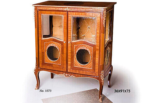 French Louis XV style ormolu-mounted sans traverse veneer inlaid Display Cabinet; resting on handsome ormolu mounted cabriole legs; the interior upper half is upholstered in capitonné style, the lower half of the door is adorned with an oval medallion encircled with ormolu floral motifs and closed by pierced ormolu gallery. Available per request with upholstered tufted back or mirror back as displayed