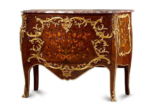 French 19th century Louis XV Rococo style marquetry and Rocaille ormolu commode after the model by Francois Linke, The commode is raised on slender cabriole legs with pierced ormolu sabots and fabulous large chutes that rise up to very impressive foliate scrolled pierced ormolu mounts at each side, The two drawers inlaid with a central ribbon tied marquetry flower bouquet surrounded with a ravishing C scrolled foliate Rocaille and Rococo style frame crested with acanthus shell motif ormolu mount, the foliate handles ramified from the continuous frame, all above a scalloped bottom frieze decorated with sea shell and foliage on a waterfall amidst a continuing C scrolled foliate ormolu mounts. The frieze and legs are also trimmed with an ormolu filet. All below a serpentine shaped moulded eared marble top