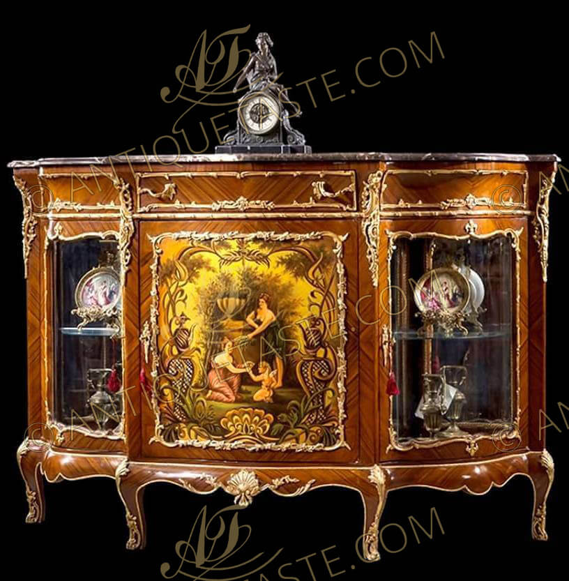 A luxuriant Napoléon III gilt-ormolu mounted veneer inlaid and Vernis Martin serpentine shaped side display cabinet, after the model by Henri Picard Circa 1880, The serpentine shaped marble top above an ormolu mounted frieze drawer flanked by two faux drawers to each side surrounded with rich ormolu encadrement, above three cupboard doors. The right and left display doors are flanking the central door which is decorated with a fine painted cartouche with classically dressed nymphs giving water to cupid by a well surrounded with a fine foliate ormolu encadrement. The three doors with ormolu keyhole escutcheons, The fine piece is raised on delicate four cabriole legs elabrately decorated with ormolu strapworks, shell and ormolu pierced sabots, The vernis -Martin technique became popular again in the later years of the 19th century. Patented by Guillaume and Simon-Etienne Martin in 1748, it was developed to imitate Far Eastern, particularly Japanese, lacquerware. The process uses copal and amber varnishes which are layered onto the desired surface.  The varnish is then polished with pumice powder and sealed with oil to create a smooth, glossy finish.  Many 19th century painters added a craquelure to the varnish to imitate the original varnish of the Martin brothers as seen over 100 years earlier