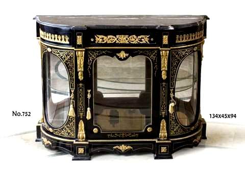 A Napoleon III Andre Charles Boulle style ormolu mounted black and parcel gilt brass Credenza Of broken D-shaped outline marble topped above one drawer ornamented with ormolu acanthus scrolls and ormolu bulls flanked with two blocks ornate with ormolu rosettes and two convex sides decorated with ormolu palmettes with glazed doors enclosing shelves and mirrors, divided by fine chiseled volute acanthus ormolu chutes with scrolled foliate and shell clasps on a conforming scalloped plinth