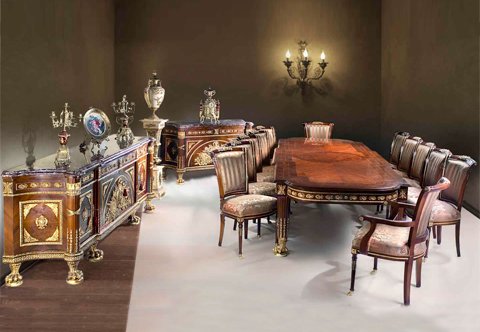 A Majestic French late 19th Century Louis XVI style opulent fifteen pieces Dining Room Set À Vantaux after the model by Guillaume Benneman and Joseph Stöckel executed for Marie-Antoinette for the Salon des Jeux at Fontainebleau and the Château de Compiègne; the fine dining set is intricately ormolu-mounted and sans-traverse veneer inlaid; ornamented with oak-leaf frieze and royal Bee emblem, ormolu trophies of War and heraldic Roman Revival medallion, ribbon-tied arrow-forms, acanthus rosettes and raised on acanthus-sheathed hairy ormolu paw feet; comprising of a grand dining table, ten dining chairs, pair of armchairs, grand buffet and one commode.