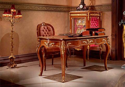 French 18th century Louis XV style ormolu-mounted desk after the model by Bernard Ebeniste; The desk is raised by impressive robust cabriole legs terminating with foliate pierced turned ormolu sabots extended with hammered fluted ormolu strap to the top where each leg is adorned with exquisite and richly chased ormolu busts of a classical maiden ornamented with and anthemion from headdress, foliate works, acanthus leaf volutes and blossoming garlands; The arbalest shaped apron has three drawers with foliate handles, all within ormolu borders, the drawers on the sides are decorated with corner thriving branch, the central drawer, the faux back and the sides are finely embellished with a central ormolu mount of a wigged female mask with leafy headdress amidst flourishing foliate works and a braided hair outspread under the chin; The arbalest shaped veneer crossbanded leather topped surface is decorated with a leaf and dart on cyma recta ormolu gallery surrounding