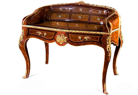 A fine French Louis XV style concave-shaped, ormolu-mounted veneer inlaid Bureau de dame after the model by Francois Linke, The serpentine concave upper structure is surmounted with a fabulous ormolu shell issuing a fine detailed foliate ormolu filet in a satin and burnish finish extends on each curved side, The interior is fitted by six various size drawers with ormolu ring handles, the gilt-tooled inset leather writing surface above a fabulous drape-shaped wrap-around ormolu band , The scalloped frieze centered with a remarkable ormolu flower bouquet basket flanked by two shaped drawers with foliate ormolu handles, The desk is raised on cabriole legs decorated by richly top chased ormolu pierced ormolu chutes, terminated with hairy ormolu paw feet sabots, with hammered ormolu filet running along the internal sides of the legs and all the lower contour of the desk