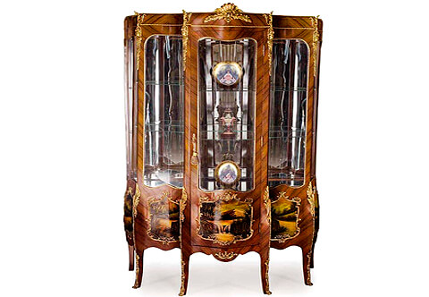 A palatlial Louis XV, and Vernis Martin style, ormolu-mounted veneer inlaid Grand Vitrine, on the manner of Francois Linke, Grande vitrine, Louis XV 3 corps bois de violette Panneaux Vernis Martin, The quarter sans traverse veneered shaped top apron crested with an astonishingly chiseled ormolu shell cabochon issuing two wreath branches on the protruding central three-quarter length glazed door, Exquisitely crafted four ormolu female busts chutes on each top corner surmounted with scrolled acanthus branches and four acanthus ormolu mount chutes on the lower quarter extending on the cabriole slender splayed legs with foliate ormolu filet to the scrolled ormolu sabots, The lower quarter with five Vernis Martin harmonious outdoor panels within scrolled ormolu borders