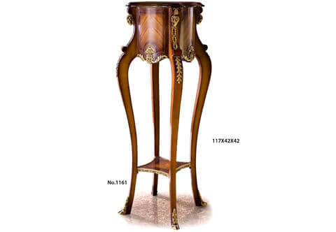 An extremely elegant French mid 19th Century Régence Louis XV early Rococo style ormolu-mounted and sans traverse crossbanded veneer inlaid grand Plant Stand Pedestal; The beautiful pedestal is raised on four convex curved slightly splayed legs adorned with four ormolu leafy hoof feet sabots and connected with a lower tier competently sans traverse veneer and filet inlaid and decorated with handsome swaging draped garlands ormolu mounts; Each leg is leading up transforming to concave shape support tops adorned with imbricated leafy ormolu mounted headed with finely chiseled and most detailed ormolu ram heads surmounted with an ormolu anthemion; the supports are surrounding the thick circular scallop shaped top tier which displays most decorative mottled designs with canted corners; the top tier is beautifully sans-traverse veneer and filet inlaid and ormolu-mounted with exquisite blossoming flower bouquet issuing scrolling acanthus leaves.