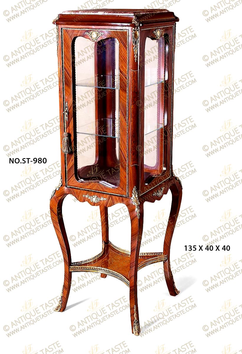 A sophisticated French Louis Quinze style patinated ormolu-mounts and sans-traverse double cut veneer inlaid grand Vitrine Pedestal; The surmounting inset marble top rests within a concave shaped frieze ornamented on each corner with an ormolu acanthus leaf, all above the display tier of two glass panes inside and four scalloped shape glazed panels adorned on top center of each of them with a finely chiseled foliate ormolu Cartouche and delicate ormolu frame, the central door has an ormolu pierced foliate keyhole escutcheon, the four corner supports are double veneer inlaid within a delicate filet and ornamented on top with stunning ormolu long chutes representing suspending ribbon-tied pierced foliate ovoid Cartouche; The lower supporting table has a fine double scalloped shaped reserve sans-traverse veneer inlaid and centered on each side with an ormolu mount of a Cartouche issuing foliate branches; each leg corner is embellished with a fine long scrolling acanthus leaf ormolu chutes connecting the upper and lower tiers; The fine piece is raised on four robust splayed cabriole legs, sans-traverse veneer inlaid, ormolu mounted with pierced scrolling foliate ormolu sabots and connected with an exquisite double veneer inlaid concave sides X stretcher ornamented with a doubled smooth and burnished ormolu band surmounted with a pierced gallery to each side.