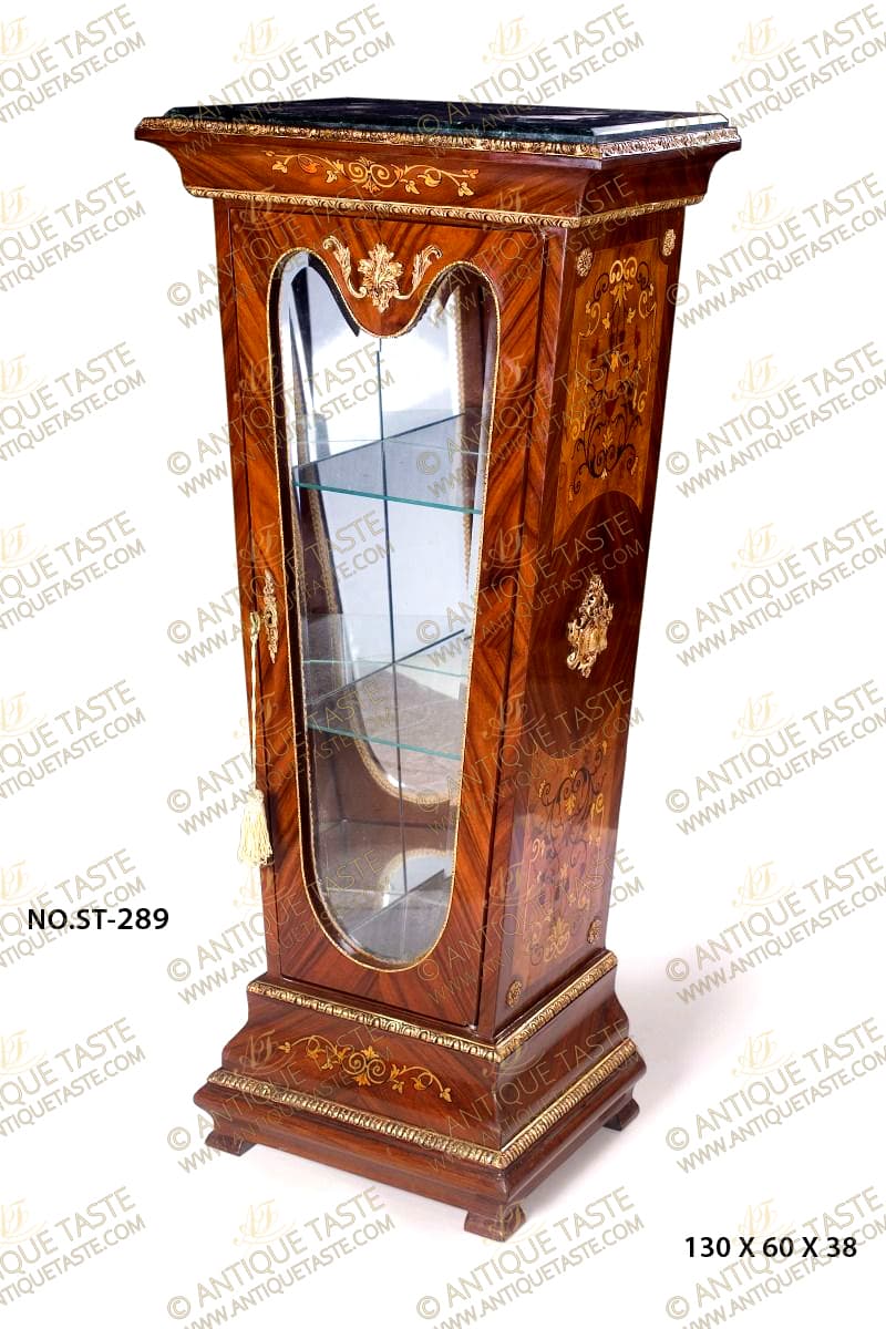 An exceptional French Louis XVI style ormolu-mounted veneer and exotic floral marquetry inlaid grand Pedestal Vitrine; The pedestal of a tapered form and is raised by a fine square base with an elegant and most decorative concave and convex stepped designs on mottled feet, adorned with pair of ormolu bands, Egg-and-Dart ormolu band on the top and reel bands on the bottom with a central foliate scrolling marquetry pattern; The square tapered central part has a mirrored interior with two glass panes and displays exquisite sans-traverse veneer and floral marquetry inlays on each side of Rinceau style, acanthus leaves, scrolling blossoming Tendrils in Rinceau and vine leaves flanked with circular ormolu rosettes on the four corners up and down and centered with a wonderfully executed large pierced foliate Cabuchon ormolu mount; the central sans-traverse veneer inlaid front door is of an arbalest shaped top and ovolo form bottom, adorned with a delicate ormolu band to the contour, foliate ormolu keyhole escutcheon and a beautifully chiseled central ormolu mount on the top of a large ramified ormolu acanthus leaf; The surmounting cavetto protruding cornice topped with a Cyma Recta style ormolu band and bottomed with an ovolo Egg-and-Dart ormolu band and centered with a foliate scrolling marquetry pattern and resting above the canted inset marble top.