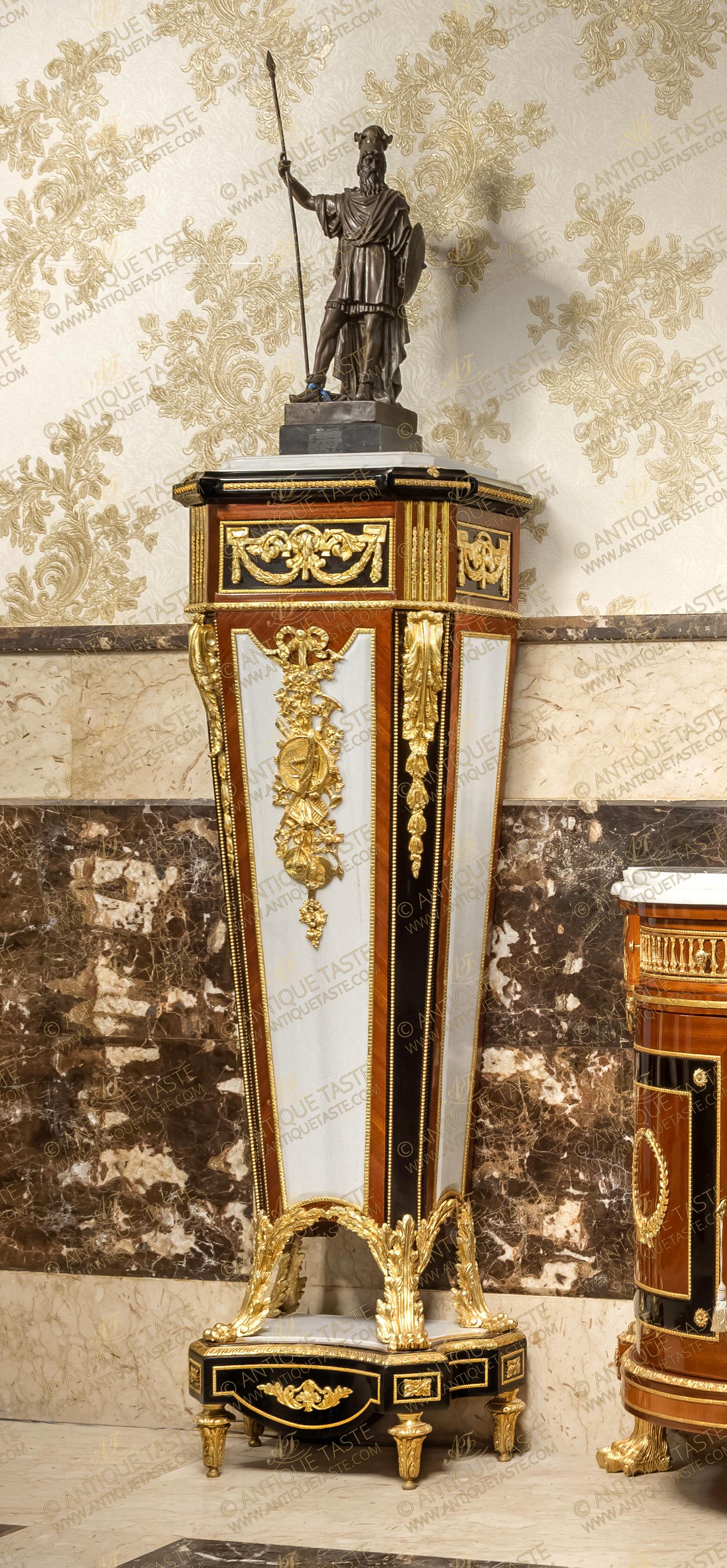 A royal and most prestigious pair of French late 18th century Louis XVI style gilt-ormolu-mounted, ebonized, veneer and marble inlaid monumental pedestal stand after the masterpiece model by the master ébéniste Jean-Henri Riesener circa 1785; Surmounted with a leveled canted corners inset marble top within an ebonized protruding canted corners cornice ornamented with ormolu foliate leaves and beaded ormolu bands; the recessed canted corners frieze below is embellished with finely chiseled ormolu mounts of scrolling Greek Keys issuing suspending swaging bay leaf garlands and scrolling acanthus leaves with a beaded encadrements and flanked by fluted gilded canted corners decorated with ormolu chandelles; all above another ormolu beaded trim; The central body of tapering form is ebonized, sans traverse veneer inlaid and marble mounted in fabulous harmony, the central front part is adorned with an exquisitely hand chiseled large ormolu mount of a suspending ribbon-tied blossoming foliage and blowing musical instruments on the marble background enframed with a hammered ormolu band and flanked by an ebonized canted corners accented with striking long ormolu chutes of acanthus volute leaves elongated with imbricated ormolu leaves and framed with ormolu beaded band; the body terminates in concave form resting below on ravishing scrolling acanthus-sheathed ormolu paw feet; The concave sides plinth below is resting on beautiful acanthus ormolu toupie feet and surmounted with an inset marble top of the same form with a hammered ormolu band on the edge, square ormolu rosettes and scrolling foliage ormolu mount to the front, all within ormolu hammered encaderements. The original pedestal attributed to Jean-Henri Riesener was received by Master in 1768 and executed in 1785, now in the permanent collection of the Musée du Louvre in Paris. This was one of the most popular of the 18th century models admired by the finest cabinetmakers in the second half of the 19th century and it is interesting to note that a barometer version, also in the Louvre, was made by the cabinetmaker Guillaume Grohé in the mid-19th century. François Linke also reproduced this model under archive number 852. Along with André-Charles Boulle and Charles Cressent, Riesener was arguably one of the three greatest French ébénistes of the 18th century. As a young man, he entered the workshop of Jean-François Oeben (maître in 1761 but previously active as an ébéniste du Roi), eventually taking over the workshop after Oeben's death in 1763, and marrying his widow some four years later. He is renowned for having completed the famous bureau du Roi Louis XV, designed and started by Oeben and made with the collaboration of another young apprentice in the workshop, Jean-François Leleu.