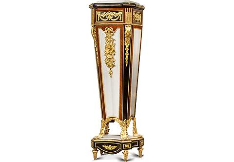 A royal and most prestigious pair of French late 18th century Louis XVI style gilt-ormolu-mounted, ebonized, veneer and marble inlaid monumental pedestal stand after the masterpiece model by the master ébéniste Jean-Henri Riesener circa 1785; Surmounted with a leveled canted corners inset marble top within an ebonized protruding canted corners cornice ornamented with ormolu foliate leaves and beaded ormolu bands; the recessed canted corners frieze below is embellished with finely chiseled ormolu mounts of scrolling Greek Keys issuing suspending swaging bay leaf garlands and scrolling acanthus leaves with a beaded encadrements and flanked by fluted gilded canted corners decorated with ormolu chandelles; all above another ormolu beaded trim; The central body of tapering form is ebonized, sans traverse veneer inlaid and marble mounted in fabulous harmony, the central front part is adorned with an exquisitely hand chiseled large ormolu mount of a suspending ribbon-tied blossoming foliage and blowing musical instruments on the marble background enframed with a hammered ormolu band and flanked by an ebonized canted corners accented with striking long ormolu chutes of acanthus volute leaves elongated with imbricated ormolu leaves and framed with ormolu beaded band; the body terminates in concave form resting below on ravishing scrolling acanthus-sheathed ormolu paw feet; The concave sides plinth below is resting on beautiful acanthus ormolu toupie feet and surmounted with an inset marble top of the same form with a hammered ormolu band on the edge, square ormolu rosettes and scrolling foliage ormolu mount to the front, all within ormolu hammered encaderements. The original pedestal attributed to Jean-Henri Riesener was received by Master in 1768 and executed in 1785, now in the permanent collection of the Musée du Louvre in Paris. This was one of the most popular of the 18th century models admired by the finest cabinetmakers in the second half of the 19th century and it is interesting to note that a barometer version, also in the Louvre, was made by the cabinetmaker Guillaume Grohé in the mid-19th century. François Linke also reproduced this model under archive number 852. Along with André-Charles Boulle and Charles Cressent, Riesener was arguably one of the three greatest French ébénistes of the 18th century. As a young man, he entered the workshop of Jean-François Oeben (maître in 1761 but previously active as an ébéniste du Roi), eventually taking over the workshop after Oeben's death in 1763, and marrying his widow some four years later. He is renowned for having completed the famous bureau du Roi Louis XV, designed and started by Oeben and made with the collaboration of another young apprentice in the workshop, Jean-François Leleu.