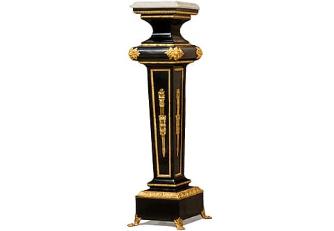 A sensational and contemporary vintage French late 19th Century Louis XVI Neoclassical style gilt ormolu-mounted and black lacquered Pedestal Stands after the model by Paul Sormani; Surmounted by a mottled veined marble top above a strait Fillet on a beaded Ovolo with Egg-and-Dart ormolu band above a concave shaped neck embellished up and down with reeded cross-band strips; the astragal below is of convex form and ormolu accented with large double detailed acanthus leaves to each corner and followed with a repeated ormolu strip below; The tapering form recessed body framed to each side with a leaf-and-dart ormolu encradement and ornamented to each center with finely chiseled large ormolu mounts of ormolu quiver and the eternal flame of life, the body terminates below above the plinth in a protruding rimmed base ornamented with a hammered cross-band ormolu strip; All above a square plinth surmounted with a fine cast acanthus Cyma-Reversa style robust ormolu trim band and raised on intricately chiseled ormolu leafy paw feet sabots; The fine pedestal is produced in different finishes in wooden veneer inlays; white lacquer and in different sizes and styles as well per clients requests as displayed.