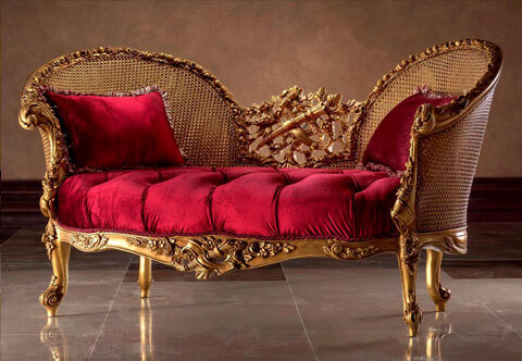 French Transitional Style Canapé en Corbeille; A loveseat sofa Marquise; Hand carved and French foil gilded; Raised by flowering acanthus cabriole turned legs flanking a carved frieze centered by a richly carved floral pierced cabochon centered by a ribbon-tied bow quiver amidst blossoming flowers; Each scrolled arm is richly handcrafted with foliate carvings and acanthus C works leading up to a continuous blossoming frame all around the contour of the wicker cane high wing C shape back which is centered with an exquisite pierced works of grape-vine trellis and blossoming acanthus leaves surrounding a ribbon-tied quiver. The fine piece is a true statement piece mixing the Rococo and Baroque carving elements in a harmonious result. One of our large volume demanded pieces.