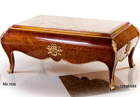 French Neoclassical Louis XV Revival style gilt-ormolu-mounted birch mahogany veneer inlaid inset marble topped Bombé shaped Couch Table, Raised by short splayed cabriole hipped legs with fine scrolled acanthus ormolu sabots connected to an ormolu chute leads up each leg to a very sensational richly chased acanthus leaf corner mount in a satin and burnished finish, The scalloped body frieze is masterfully inlaid with birch mahogany veneer, adorned by delicate acanthus leaf ormolu chased filet to the contour and central ormolu Neoclassical style medallion of ribbon tied berried laurel wreath and pair of arrows, The marble top inset within a concave border ornamented with mottled ormolu band