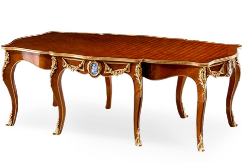 Royal French Louis XV style ormolu-mounted Parquetry and blue Wedgwood Jasperware plaque inlaid eight legs Table De Salon after the model by François Linke late 19th century, The fine scalloped top is inlaid with delicate trellis parquetry pattern surrounded by a veneer fillet and moulded burnished and satin ormolu border above a recessed scalloped body with an ormolu trim to the contour and issuing eight cabriole legs; each is ornamented by a finely chiseled detailed pierced scrolled acanthus corner mount and terminating by a delicate acanthus leaf sabot; To each side is a central medallion of a blue and white Wedgwood Jasperware plaque encircled by an ormolu band surmounted by a pair of hung ormolu laurel wreath and flanked by a pair of harmonious ormolu bands adorned by hung swaging garlands; the same design is repeated on the central frieze of the protruding pair of legs