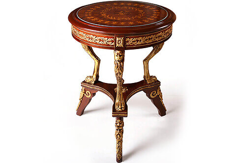 A striking Italian Louis XVI ormolu-mounted veneer inlaid and marquetry side table, The unique end table with a foliate marquetry top, above a circular ormolu mounted  apron ornamented with a scrolled pierced laurel wreath plaque within a twisted ormolu filet separated by block ornamented with ormolu rosettes, supported by ormolu leafy mythological head monopodia terminating in pawed feet, above an ormolu mounted concave plinth ornamented with ormolu bands and centered with a leafy cone finial, Raised on another three shaped legs ornamented with ormolu satyr masks sabots accented with acanthus leaves beards. 