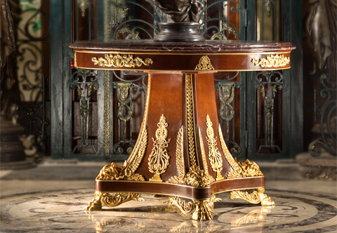 A Majestic and extremely decorative Napoleon III second Empire style ormolu-mounted veneer inlaid and marble topped Center Table richly adorned with luxuriously chased ormolu mounts, resting on striking acanthus paw feet topped with triangular base and central support displays an exceptional curved tapered design ornamented with Empire Neoclassical ormolu mounts leading to the marble topped ormolu mounted circular top