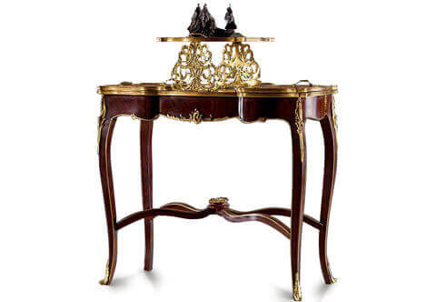 An Exquisite Louis XV style gilt-ormolu-mounted palisander wood tray-top serving table after the model by François Linke and Léon Messagé, Paris, Circa 1900, Of serpentine shape, the upper section with lift-off tray, above delicate gilt-ormolu foliage supports, the segmented top fitted with a further two shaped ormolu mounted, lift-off trays, above a shaped body ornamented centered with a louis xv foliate shell mount extended to a delicate ormolu bands all over, raised on shaped ormolu acanthus headed cabriole tapering legs joined by a wavy 'X'-shaped stretcher surmounted by a foliate ormolu mount, with ormolu acanthus leaves sabots